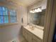 Bathroom with vanity, bathtub, and window with shutters at 220 Spalding Lake Pl, Atlanta, GA 30350