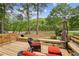 Deck overlooking tranquil river with wicker chairs and red cushions at 1053 Riverbend Club Se Dr, Atlanta, GA 30339