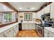 Bright kitchen features white cabinets, stainless steel appliances, and terracotta tile floors at 1053 Riverbend Club Se Dr, Atlanta, GA 30339