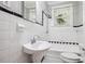 Updated bathroom with white tile, pedestal sink, and a shower/tub combo at 906 Courtenay Ne Dr, Atlanta, GA 30306