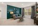 Versatile bonus room with a gray sofa, dark green accent wall, and plenty of natural light at 619 Whitman (2200) Ln, Stockbridge, GA 30281