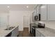 Modern kitchen with gray cabinets, granite counters, and pantry at 576 Whitman (2020) Ln, Stockbridge, GA 30281