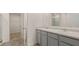 Double vanity bathroom with grey cabinets and neutral tile floors at 576 Whitman (2020) Ln, Stockbridge, GA 30281