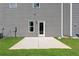 Gray house with small grassy yard and concrete patio, featuring a back door at 1916 School House Ln, Temple, GA 30179