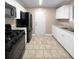 Kitchen with white cabinets, black appliances, and tile floor at 125 Cainwood W Ct, Atlanta, GA 30349