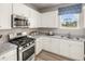 Modern kitchen with stainless steel appliances and white cabinets at 1261 Arnhem Dr, Hampton, GA 30228