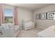 Bedroom with crib, seating, and window with pink curtains at 1261 Arnhem Dr, Hampton, GA 30228