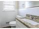 Bathroom with granite countertop, white tile, and updated fixtures at 2775 Tilson Rd, Decatur, GA 30032