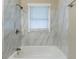 Modern bathroom with marble tile and a large bathtub at 6168 Ellis St, Douglasville, GA 30134