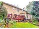 Tan house with large deck and partially visible landscaped yard at 1563 Poplarwood Nw Ln, Lawrenceville, GA 30043
