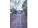 Stone pathway winds through a wooded backyard, illuminated by solar pathway lights at 1563 Poplarwood Nw Ln, Lawrenceville, GA 30043