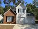 Two-story house with brick and white vinyl siding, two-car garage, and landscaping at 3423 Homeward Trl, Ellenwood, GA 30294