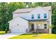 Two-story house with white siding, stone accents, and a two-car garage at 134 Henley St, Canton, GA 30114