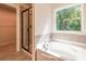 Bathroom featuring garden tub, walk-in shower, and large window at 134 Henley St, Canton, GA 30114
