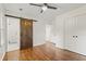 Bedroom with hardwood floors, barn door, and access to bathroom at 2127 Whites Mill Rd, Decatur, GA 30032