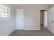 Simple bedroom with neutral walls, carpet flooring, and access to hallway at 6230 Kensington Ct, Austell, GA 30106