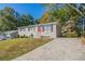 Ranch home with a newly paved driveway and mature trees at 6230 Kensington Ct, Austell, GA 30106