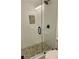 Modern shower with glass enclosure, pebble floor, and mosaic tile accent at 2534 Creekview Sw Dr, Marietta, GA 30008