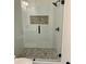 Modern shower with glass enclosure, pebble floor, and mosaic tile accent at 2534 Creekview Sw Dr, Marietta, GA 30008