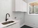 Modern laundry room with white cabinets and marble tile at 1281 Avalon Ne Pl, Atlanta, GA 30306