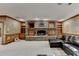 Open basement area with stone fireplace, built-in shelves, and plush leather couch at 2701 Stilesboro Nw Ln, Acworth, GA 30101