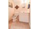 Small powder room with toilet and vanity. Neutral color scheme and tile flooring at 801 Hampton Sw Pl, Marietta, GA 30064