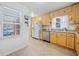 View of kitchen with light wood cabinets, stainless steel appliances, and a window overlooking the backyard at 5239 Phillips Dr, Morrow, GA 30260