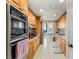 Galley kitchen with wood cabinets and modern appliances at 2660 Peachtree Nw Rd # 18G, Atlanta, GA 30305