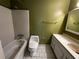 Bathroom with white tiled tub, olive green walls, and vanity at 1101 Lenox Ne Way # 1101, Atlanta, GA 30324