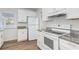 White kitchen features granite countertops, stainless steel appliances, and a modern range hood at 1246 Lyle Ave, East Point, GA 30344