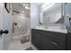 Modern bathroom with walk-in shower and dark vanity at 1368 New Hope Rd, Lawrenceville, GA 30045