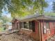 Side view of a brick home with black shutters and lush trees at 2986 Harlan Dr, Atlanta, GA 30344