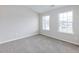 Bright bedroom featuring two windows and grey carpet at 2397 Sardis Chase Ct, Buford, GA 30519