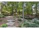 Stone steps lead to a serene pond, nestled in a wooded backyard at 1400 Lamont Cir, Dacula, GA 30019