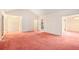 Open living space with pink carpet and access to other rooms at 175 Carriage Gate Dr, Sharpsburg, GA 30277