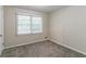 Well-lit bedroom featuring carpet flooring and a large window at 6263 Green Acres Sw Dr, Covington, GA 30014