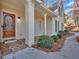 Inviting front porch with stone flooring and a wooden front door at 4995 Artisan Nw Way, Kennesaw, GA 30152