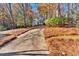 Long driveway leading to a charming two-story house with autumn landscaping at 4995 Artisan Nw Way, Kennesaw, GA 30152