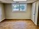 Finished basement room with new vinyl flooring and a large window at 1120 Buckhurst Dr, Atlanta, GA 30349