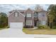 Two-story house with brick facade and a large driveway at 4203 Shandi Cv, Hoschton, GA 30548