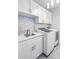 Bright laundry room with white cabinets and modern appliances at 145 Oak Forest Dr, Oxford, GA 30054