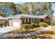 Brick ranch house with an attached garage, landscaping, and a paved driveway at 2639 Odum St, Snellville, GA 30078