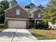 Brick two-story house with attached garage and landscaped lawn at 2451 Overlook Ave, Lithonia, GA 30058