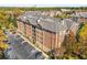 Aerial view of a brick apartment building with ample parking and fall foliage at 2300 Peachford Rd # 1209, Atlanta, GA 30338