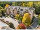 Aerial view of a brick apartment building with fall foliage and a pool at 2300 Peachford Rd # 1209, Atlanta, GA 30338