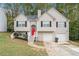 Two-story house with a red door, two-car garage, and landscaped yard at 6943 Fairway Trl, Austell, GA 30168