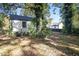 View of the backyard with a white brick house and large trees at 3060 Washington Rd, Atlanta, GA 30344