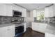 Modern kitchen featuring white cabinets, granite countertops, and tile backsplash at 3060 Washington Rd, Atlanta, GA 30344