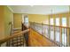 Upstairs hallway with hardwood floors and an ornate railing at 225 Asante Dr, Ellenwood, GA 30294