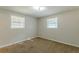 Well-lit bedroom with neutral walls, carpet, and two windows at 6275 S Skyline Dr, Douglasville, GA 30135